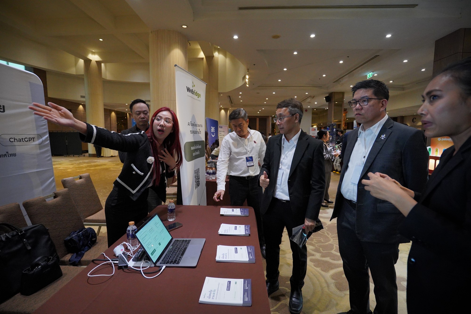 ผู้เข้าร่วมงานชมการเปรียบเทียบคำตอบ AI จีนกับ ChatGPT ที่บูธ We Bridge